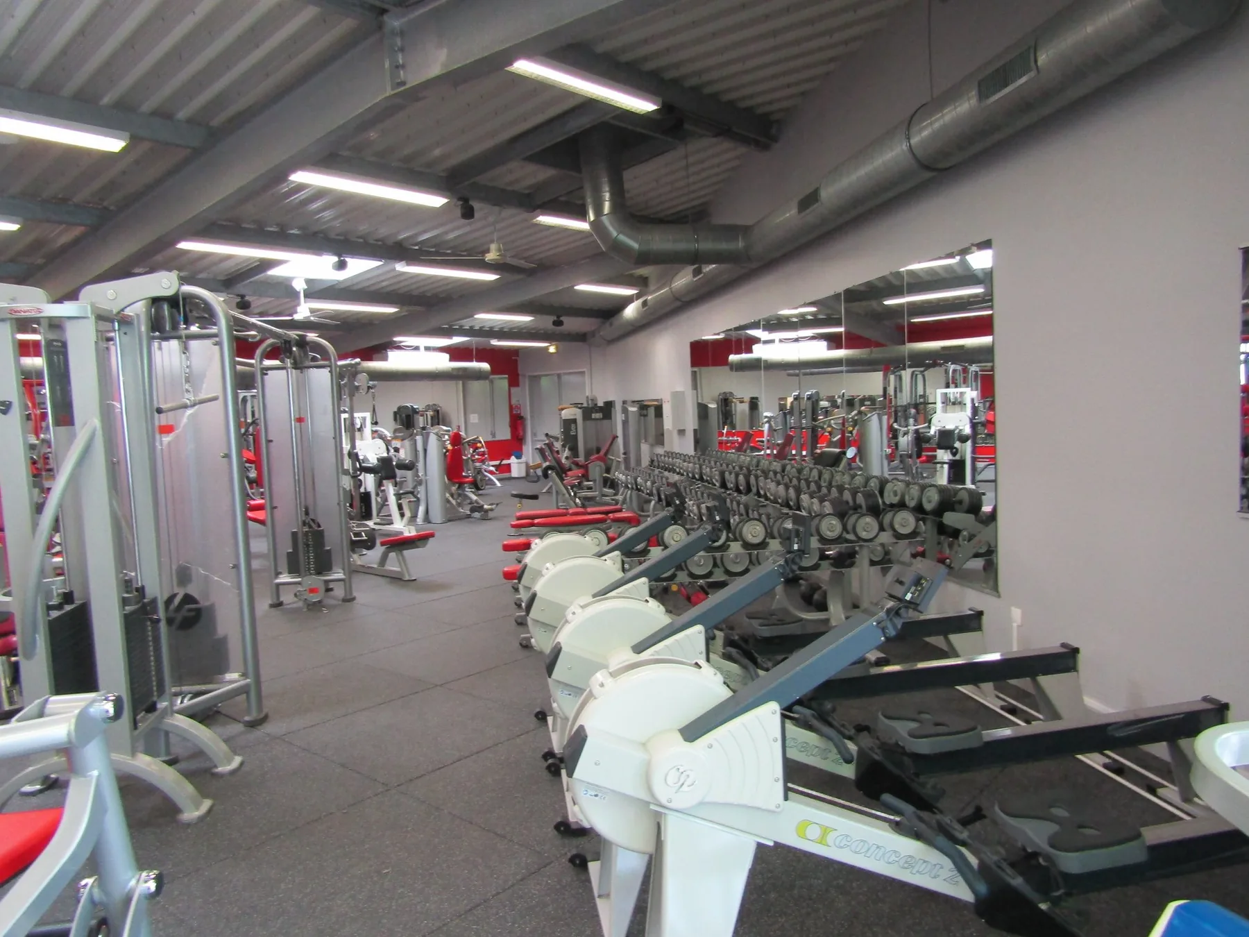 Salle de fitness équipée avec rameurs et machines de musculation